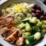Greek Chicken Power Bowl — Protein-rich chicken with cucumber, olives, and lemon rice.
